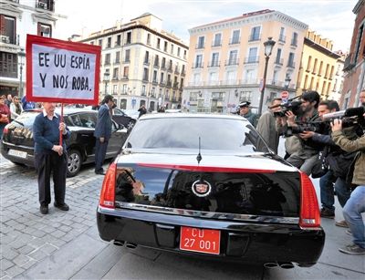 28日，美国大使乘车赴西班牙外交部解释监听事件，民众举着写有美国间谍字样的牌子进行抗议。
