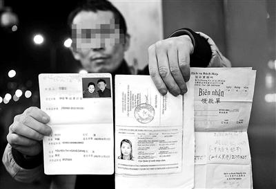 贺先生向记者出示他与越南妻子的结婚证、新娘护照和部分相关交费单据 摄影/本报记者　袁艺