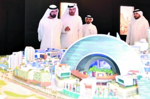 阿联酋总理（左）听取迪拜控股公司总裁（中）对“世界商场”的讲解。