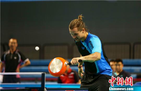 9月17日，2016中国(陵水)中欧乒乓球世界冠军表演赛在海南陵水举行，来自中国和欧洲的八大乒坛明星齐聚于此分为四组强强对决。图为来自丹麦的梅兹以铁锅为球拍参与互动。　陈思国 摄