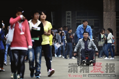 10月16日，保险职业学院，毕明哲推着坐轮椅的王理走在校园中。图/记者陈勇