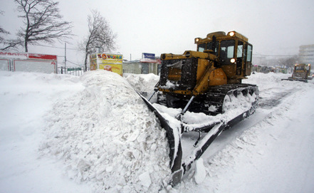 铲车在清理道路积雪。