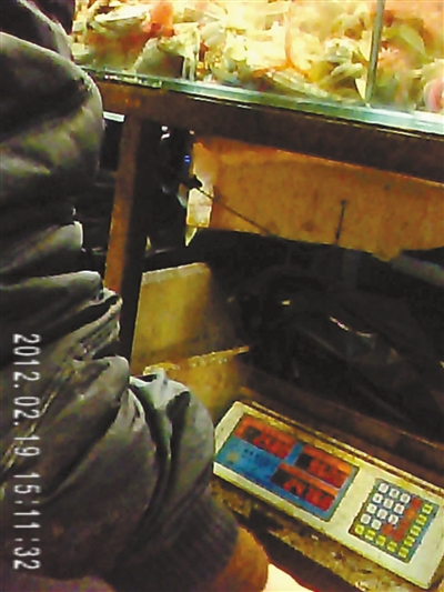 2月19日，京深海鲜市场S027号摊前，4只海蟹显示5斤1两多；同样的海蟹，在市场管理部公平秤上显示为2斤6两。