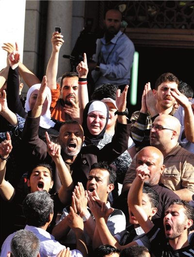 12日，人们在大马士革爆炸遇难者葬礼上高呼口号。图/东方IC