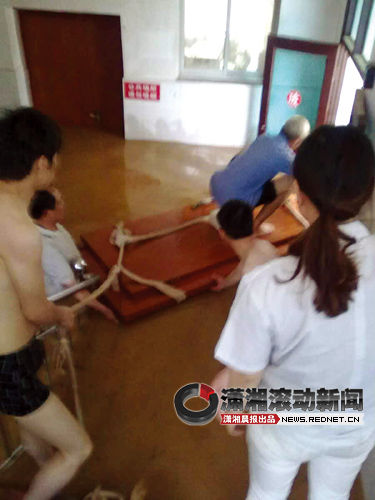 余坪乡中心卫生院，村民与护士用木板转移病人。