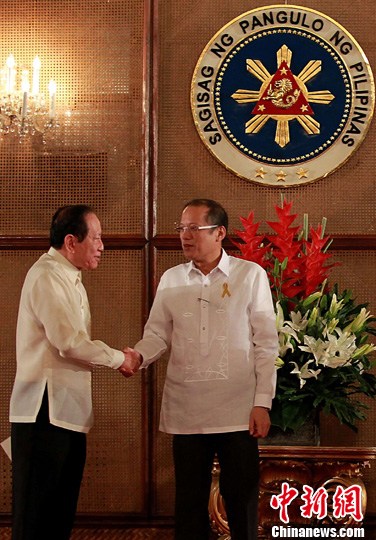 5月23日，菲律宾华裔人士李永年正式宣誓就任总统中国事务特使。图为菲总统阿基诺（右）当天在总统府为其监誓后，与李永年（左）握手祝贺。中新社发 菲总统府 摄
