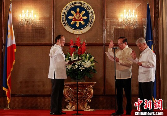 5月23日，菲律宾华裔人士李永年正式宣誓就任总统中国事务特使。图为菲总统阿基诺（中）当天在总统府为其监誓后，与李永年（右二）及其家人合影留念。中新社发 菲总统府 摄