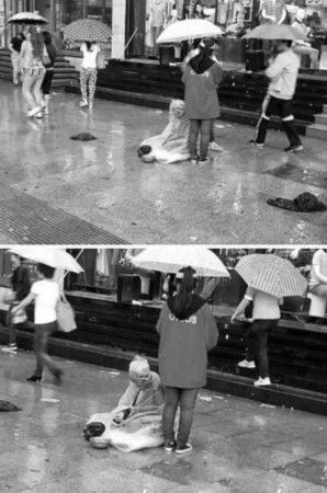 女孩雨天为乞讨老人撑伞