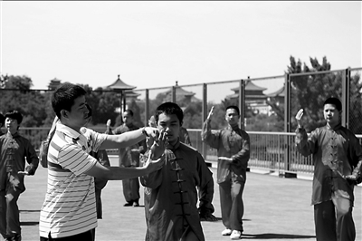 北京五中分校的老师指导学生练太极拳时讲解中医调整气息的知识。本报记者王海欣摄