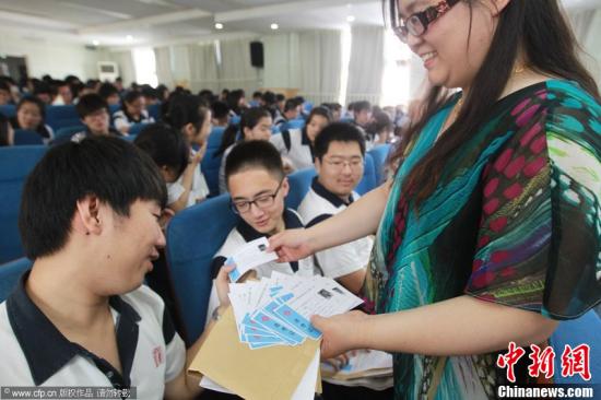 6月4日上午，包括北京第二十四中学在内的东城区全体高三考生领取了准考证和高考文具袋。图为北京市第24中学，高三学生领到准考证。付丁 摄 CFP视觉中国