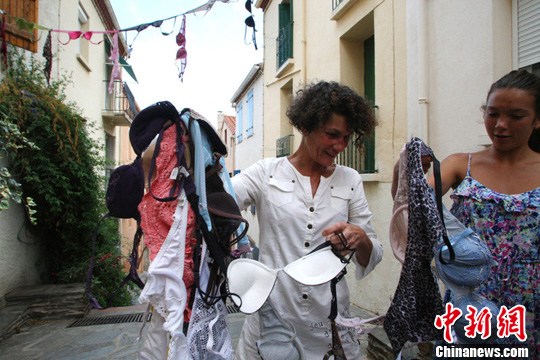 当地时间2012年7月20日，法国巴纽尔斯，两名女性手拿胸罩。东方IC 版权作品 请勿转载