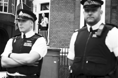 19日，英国伦敦，阿桑奇在厄瓜多尔驻英国使馆阳台上演讲，英国警察紧密“包围”厄使馆，阿桑奇寸步难离。