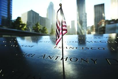 一面美国国旗插在“9·11”遗址上刻有遇难者名字的护栏上
