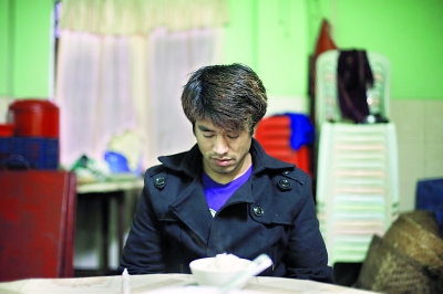 一名褪下军装的克钦军士兵在饭前祷告，次日他还将赴前线特派记者贾代腾飞 摄
