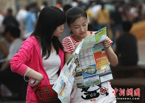 女性出游忌街头看地图 中新社记者 杜洋 摄