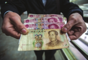 3月10日，高周拿着醉汉塞给他的320元钱，他想把这钱归还。图/记者李坤