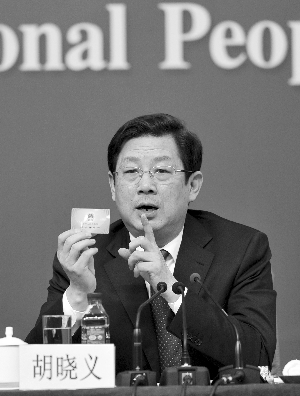 人力资源和社会保障部副部长、国务院深化医药卫生体制改革领导小组办公室副主任胡晓义手拿社保卡接受采访