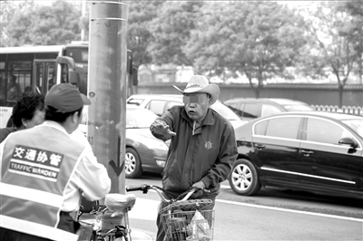地安门路口，一名骑自行车男子闯红灯后，对协管员的劝说不满，与其理论。
