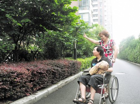 母亲推轮椅带病儿去旅行