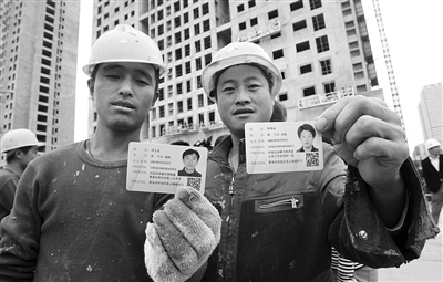 去年10月29日，山东青岛市，工人们正在展示刚领到的居住证。图/CFP