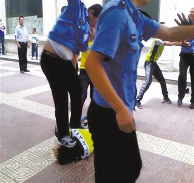 “延安城管暴力执法”视频中，刘国峰被一名城管队员跳起来踩中头部，致其昏迷。视频截图